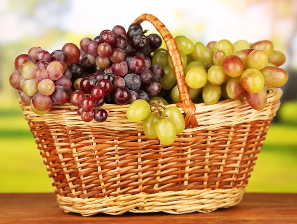 Uva fresca su stuoia di vimini su sfondo luminoso — Foto Stock