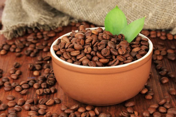 Coffee beans in bowl on wooden background — Stock Photo, Image