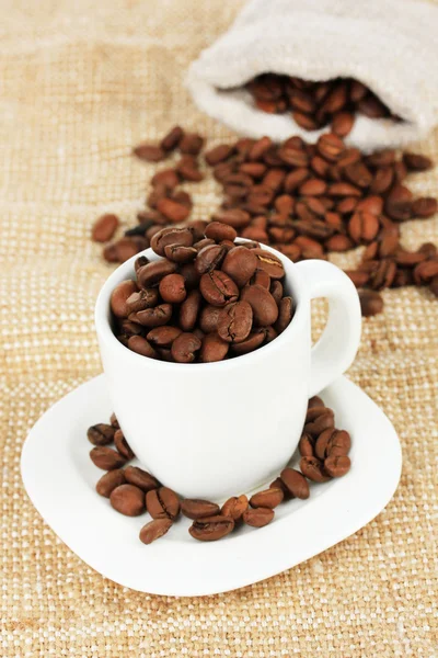 Koffie bonen in cup op tabel close-up — Stockfoto