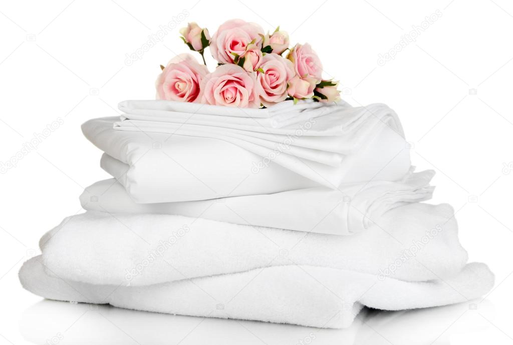 Stack of clean bedding sheets and towels isolated on white