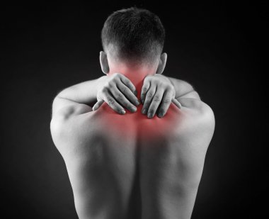 Young man with neck pain, on red background clipart