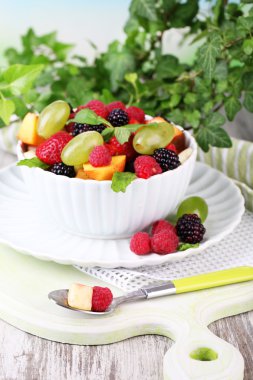 parlak zemin üzerine ahşap masa üzerinde kase meyve salatası