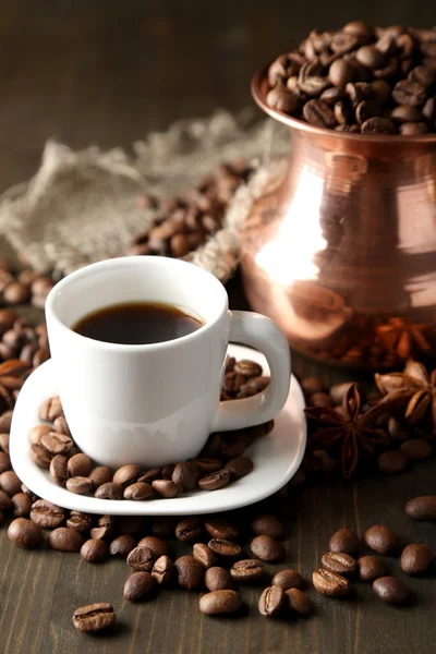 Cup of coffee and pot on wooden background — Stock Photo, Image