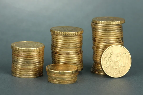 Many coins in columns on grey background — Stock Photo, Image