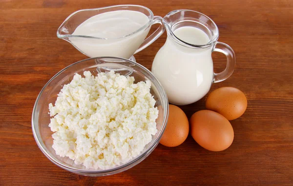 Produtos lácteos e ovos sobre fundo de madeira — Fotografia de Stock