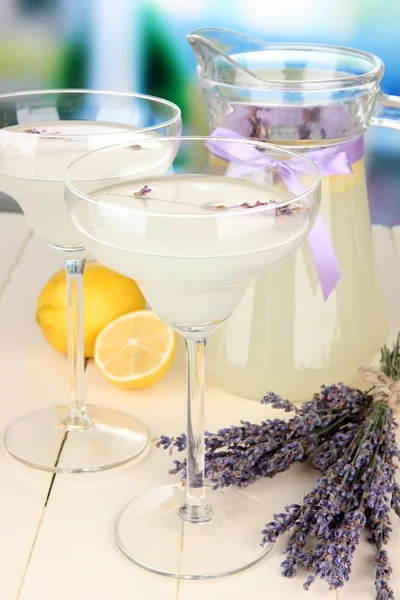 Lavendellimonade in Glaskanne und Cocktailgläsern, auf hellem Hintergrund — Stockfoto