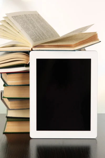 Tablet and books on light background — Stock Photo, Image