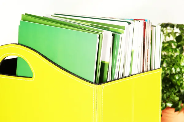 Magazines and folders in green box,on office interior background — Stock Photo, Image