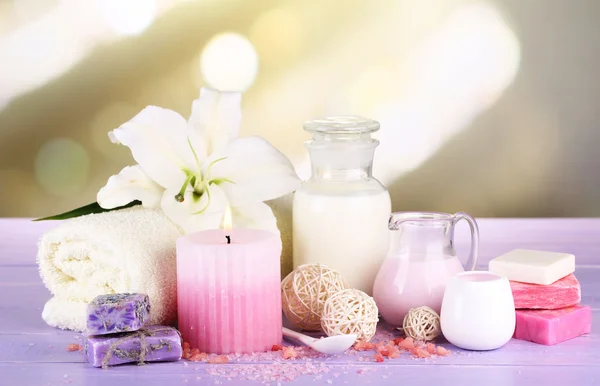 Hermoso entorno de spa con lirio en la mesa de madera sobre fondo brillante — Foto de Stock