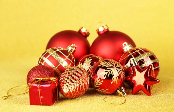 Kerstballen en kleine gift op gele achtergrond — Stockfoto