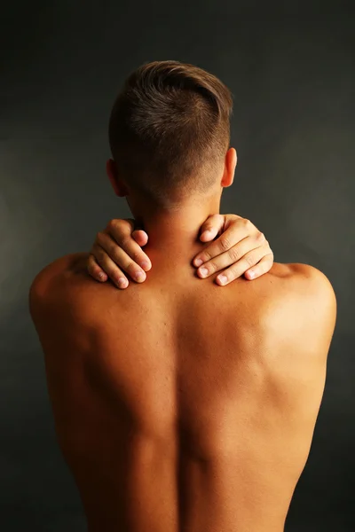 Young man with neck pain on grey background — Stock Photo, Image