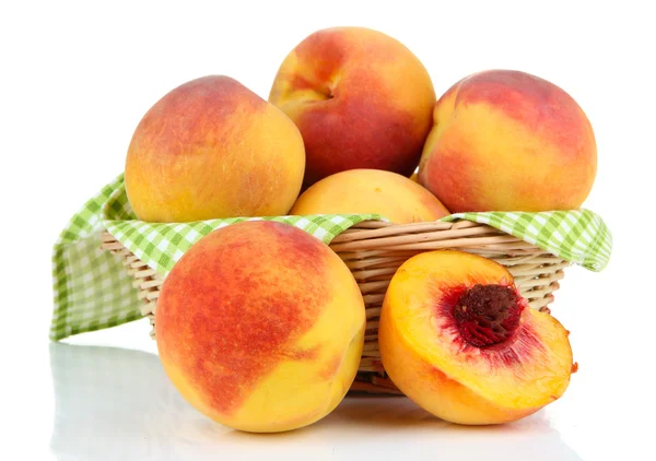 Reife süße Pfirsiche im Weidenkorb, isoliert auf weiß — Stockfoto