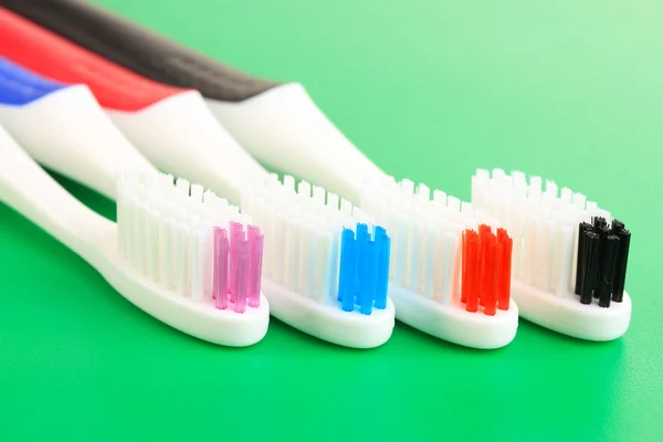 Escovas de dentes no fundo verde — Fotografia de Stock