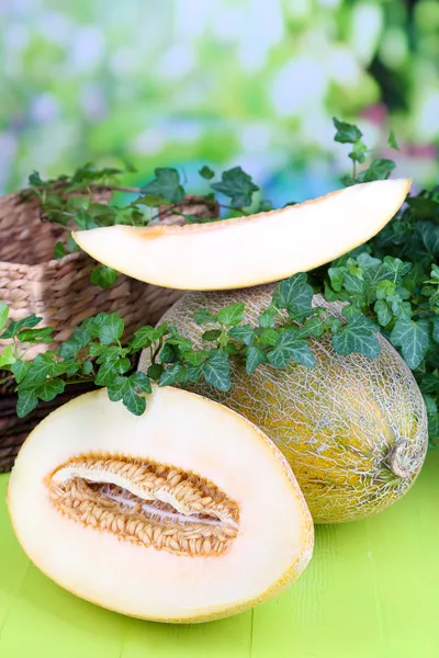 Rijpe meloenen op houten tafel op natuurlijke achtergrond — Stockfoto