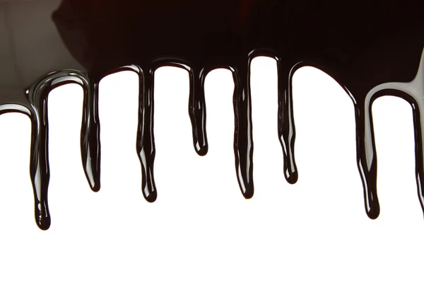 Geschmolzene Schokolade tropft auf weißem Hintergrund — Stockfoto