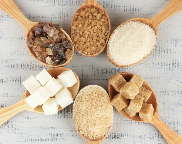 Различные виды сахара в ложках на столе крупным планом — стоковое фото