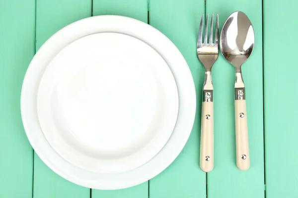 Plate and cutlery on wooden table close-up — Stock Photo, Image