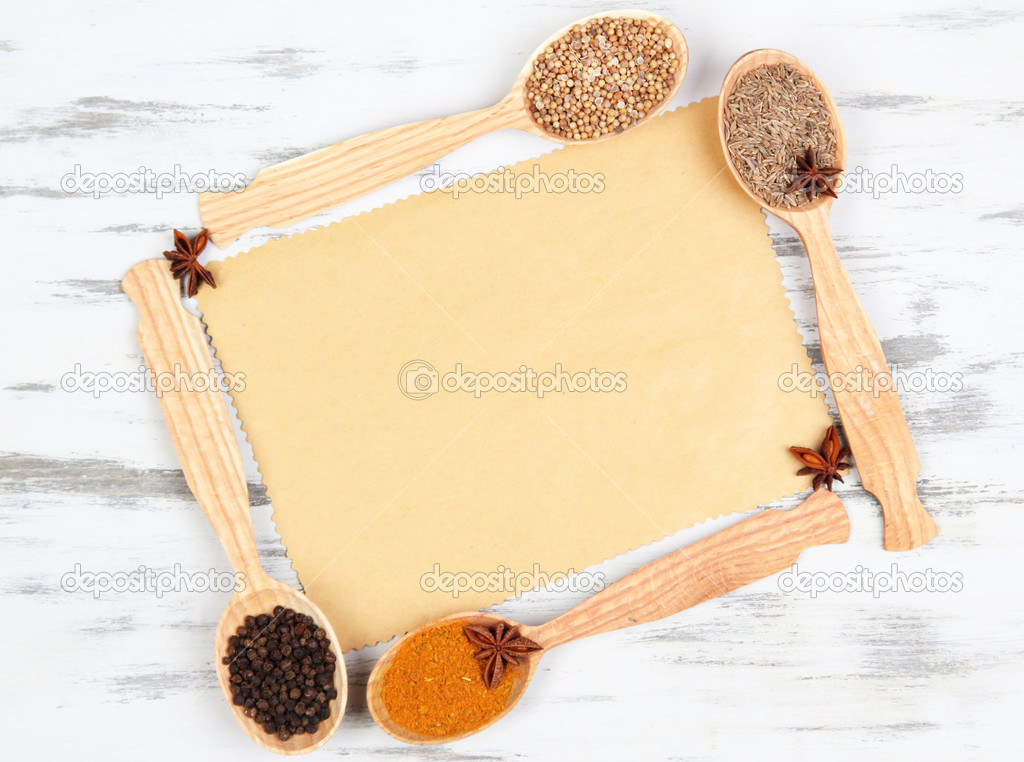 Various spices and herbs with empty white blank for recipe on wooden background