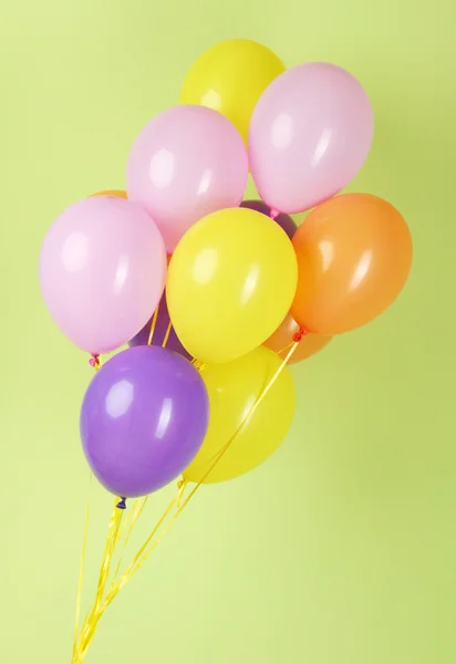 Balões coloridos sobre fundo verde — Fotografia de Stock