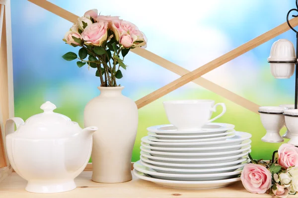 Lots beautiful dishes on wooden shelf on natural background — Stock Photo, Image