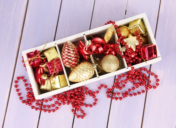 木盒子装满圣诞装饰品，彩色木制背景上 — 图库照片