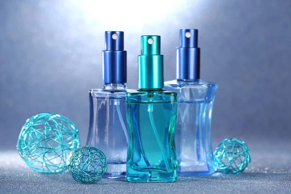 Women perfume in beautiful bottles on blue background — Stock Photo, Image