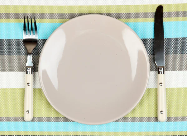 Messer, Farbteller und Gabel, auf farbigem Hintergrund — Stockfoto