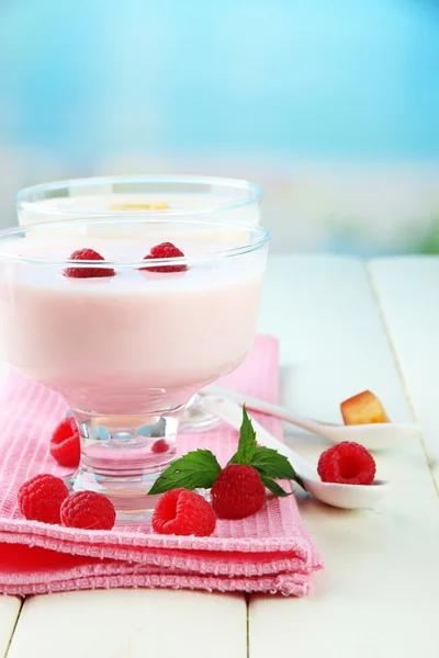 Iogurte delicioso com bagas na mesa em fundo brilhante — Fotografia de Stock