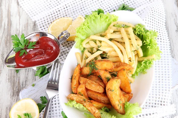 Franska frites och hem potatis på tallriken ombord på servett på träbord — Stockfoto