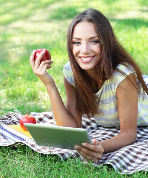 Mooi meisje met tablet in park — Stockfoto