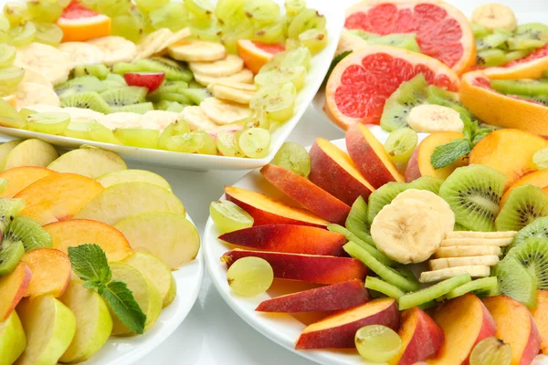 Surtido de frutas en rodajas en platos, primer plano —  Fotos de Stock