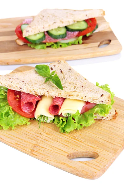Смачні бутерброди з салямі ковбасою та овочами на обробній дошці, ізольовані на білому — стокове фото