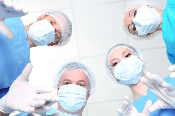 Vista de baixo de cirurgiões em desgaste de trabalho de proteção durante a operação — Fotografia de Stock