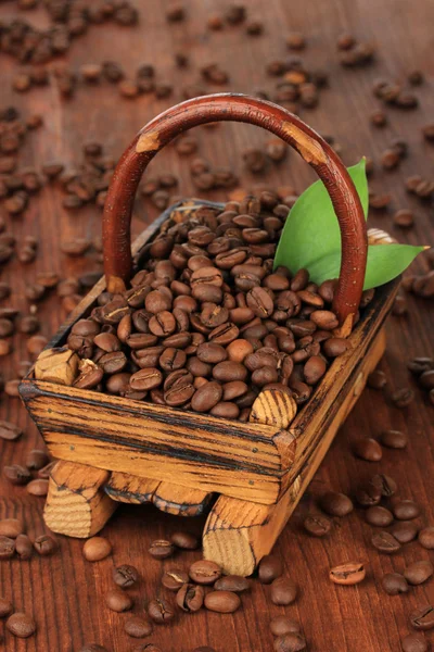 Koffie bonen in houten mand op tabel close-up — Stockfoto