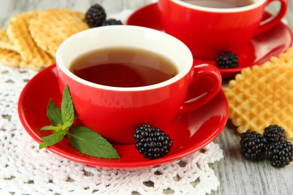 Cups of tea with cookies and blackberry on table close-up — Stock Photo, Image