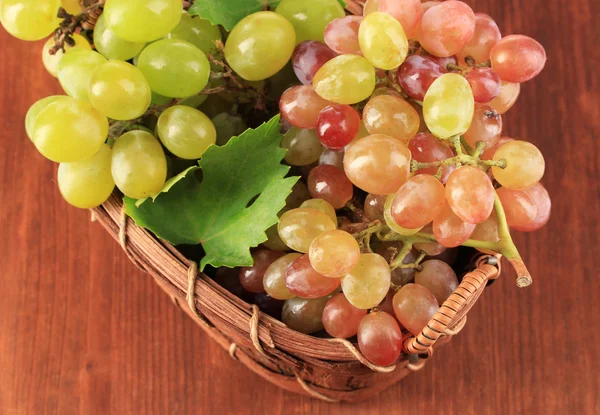 Dojrzałe słodkie winogron w kosz na drewniane tła — Zdjęcie stockowe