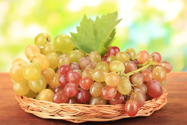 Ripe sweet grape on wooden table, on nature background — Stock Photo, Image