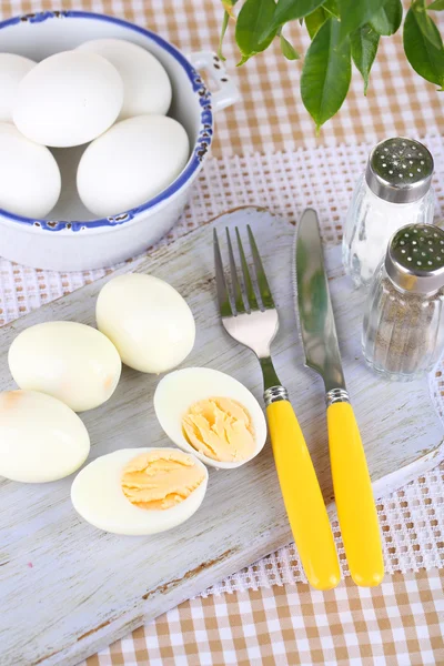 Huevos cocidos sobre tabla de madera sobre mantel —  Fotos de Stock