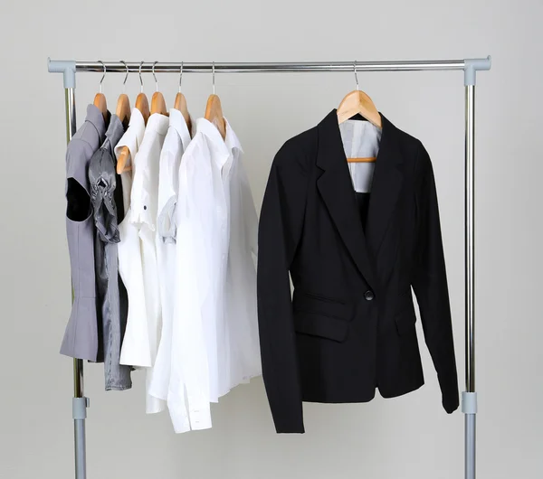 Office kleren op hangers, op grijze achtergrond — Stockfoto