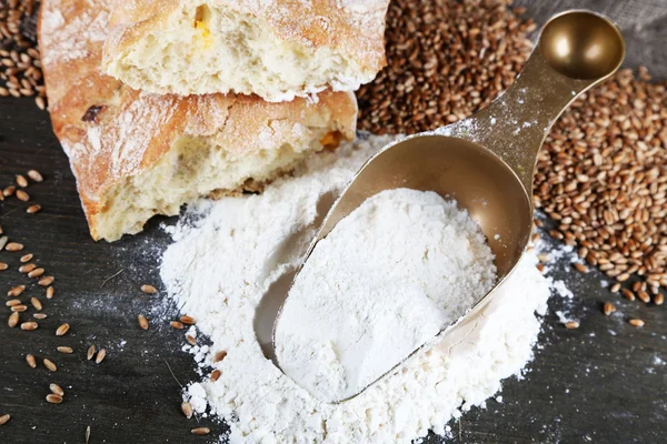 The wholemeal flour in scoop on wooden table on sackcloth background — Stock Photo, Image