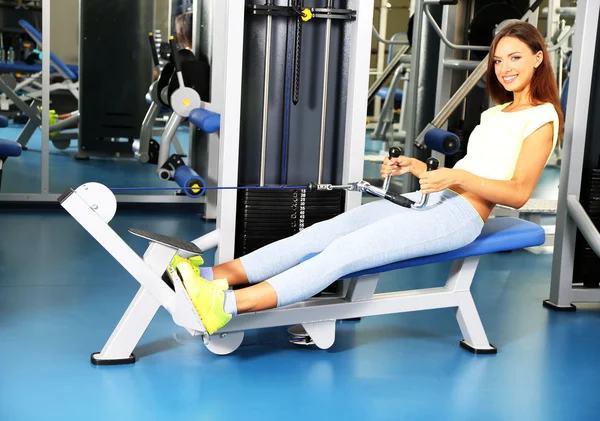 Pretty sporty girl engaged in simulator in gum — Stock Photo, Image