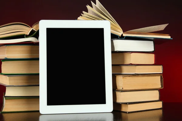 Tablette et livres sur fond lumineux — Photo