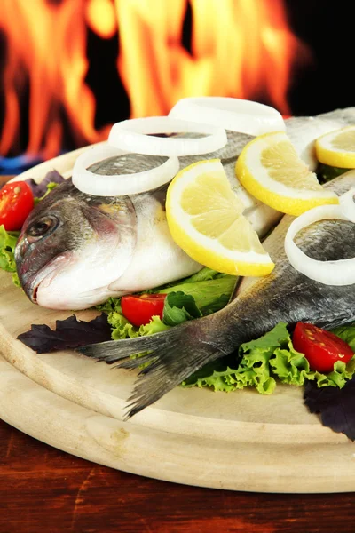 Dorado fish on table on fire background — Stock Photo, Image