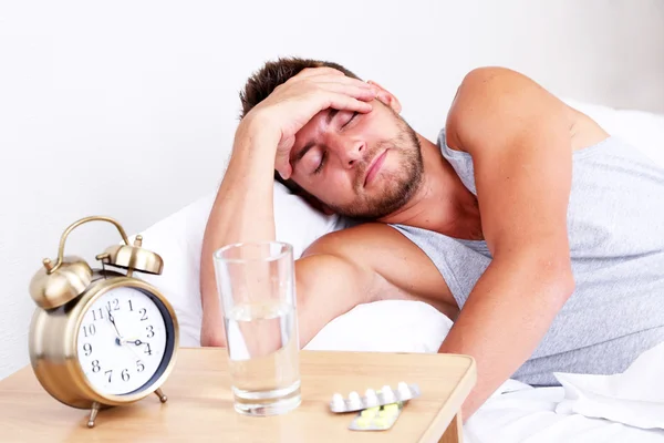 Schöner junger Mann im Bett — Stockfoto