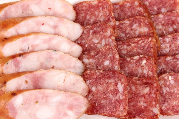 Tasty sliced sausage on plate close-up — Stock Photo, Image