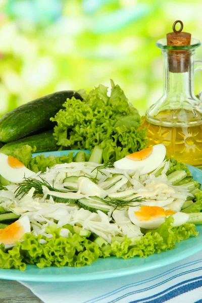 Delicious salad with eggs, cabbage and cucumbers on wooden table — Stock Photo, Image