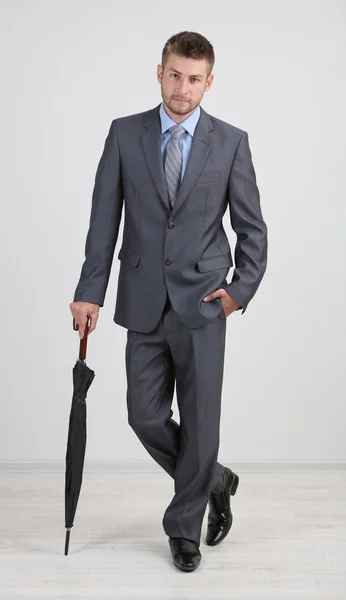 Businessman with umbrella. on gray background — Stock Photo, Image