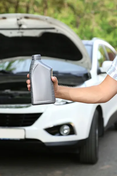 Auto mechanic hand holding motor oil — Stock Photo, Image