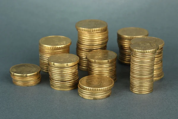 Many coins in columns on grey background — Stock Photo, Image