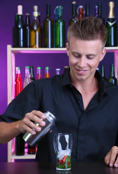 Portrait of handsome barman preparing cocktail, at bar — Stock Photo, Image